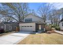 Charming two-story home with a brick and siding exterior, landscaped yard and large driveway at 1604 Temple Ave, Atlanta, GA 30337