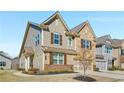 Charming two-story home featuring a brick and stone facade, complemented by shutters and a two-car garage at 2910 Bishopstone Way, Cumming, GA 30040