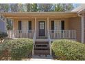 Inviting front porch with a classic door, and well-manicured shrubbery at 8633 Hilltop Rd, Jonesboro, GA 30236