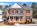 Inviting two-story brick home with a covered front porch and black shutters, creating a timeless appeal at 2517 Hampton Park Ct, Marietta, GA 30062