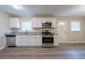 A well lit kitchen featuring stainless steel appliances, granite countertops, and durable laminate flooring at 2628 Miriam Ln, Decatur, GA 30032