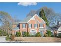 Beautiful two-story brick home with manicured landscaping, black shutters, and a charming front entrance at 9175 Etching Overlook, Johns Creek, GA 30097