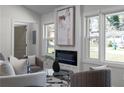 Inviting living room featuring a cozy fireplace, neutral tones, and ample natural light from large windows at 1882 Rosewood Rd, Decatur, GA 30032