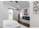 Serene main bedroom with vaulted ceilings, an electric fireplace, and a sliding barn door at 1882 Rosewood Rd, Decatur, GA 30032
