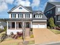 Beautiful two-story white home with a two-car garage and nicely landscaped front yard at 3020 Barnes Mill Ct, Roswell, GA 30075