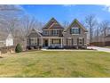 Charming two-story home featuring a well-manicured lawn and inviting front porch at 5977 Wildcreek Rd, Sugar Hill, GA 30518