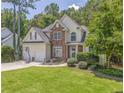 Beautiful two-story home with stone facade, lush lawn, mature trees, and attached two car garage at 119 Creekside Vw, Hiram, GA 30141