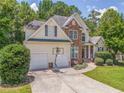 Inviting home with a landscaped yard, stone details, two-car garage, and a driveway basketball hoop at 119 Creekside Vw, Hiram, GA 30141