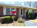 Inviting front entrance with brick and stone accents, complemented by lush landscaping and a red mailbox at 3528 Highway 42 S, Locust Grove, GA 30248