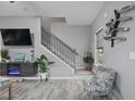 Comfortable living room with modern fireplace, sleek floors, and open staircase at 21 Samuel Nw Way, Cartersville, GA 30121