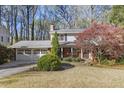 Traditional two-story home with a well-manicured lawn, mature trees, and a two-car garage at 1051 Lakeshore Dr, Avondale Estates, GA 30002
