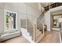 Bright entryway features a staircase with light wood steps, black iron spindles, and a bench near a window at 2587 Apple Valley Rd, Brookhaven, GA 30319