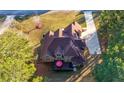 Aerial view of a two-story home with a brown roof, a deck with a red umbrella, and a spacious yard at 1415 Swiftwater Cir, Mcdonough, GA 30252