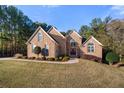 Charming two-story brick home with an arched entryway, manicured shrubs, and lush green lawn at 1415 Swiftwater Cir, Mcdonough, GA 30252