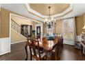 Formal dining room with tray ceiling, large windows, and hardwood floors adjacent to foyer and stairway at 960 Whitehawk Trl, Lawrenceville, GA 30043