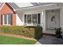 Inviting front porch with seating area and a well-maintained garden at 115 Dearing Woods Way, Covington, GA 30014