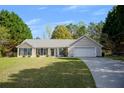 Inviting one-story home with lush green lawn and driveway leading to the attached two-car garage at 313 Ridge Hill Cir, Canton, GA 30115