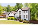 Charming two-story home with a well-manicured lawn and lush green trees at 3612 Tree View Dr, Snellville, GA 30078