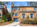 Charming brick townhome showcasing a well-manicured lawn, blue shutters, and convenient garage at 1143 Morningside Ne Pl, Atlanta, GA 30306