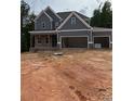 New construction home with gray siding, brick accents, and a three-car garage at 174 Pinewood Dr, Covington, GA 30014