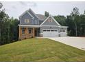 Two-story home with a covered front porch and a convenient three-car garage at 174 Pinewood Dr, Covington, GA 30014