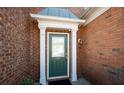 Close-up of the brick front door with white trim and security camera at 195 Finchley Dr, Roswell, GA 30076