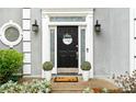Close-up of the front door with decorative wreath, sidelights, and potted plants, creating a welcoming entrance at 3993 Amberley Ln, Marietta, GA 30062