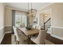Traditional dining room features elegant wainscoting, stylish chandelier, and a large window at 2687 Ashford Ne Rd, Brookhaven, GA 30319