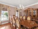 Formal dining room with a chandelier, large window, and ornate china cabinet for elegant entertaining at 612 Kristen Ct, Mcdonough, GA 30252