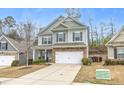 Charming two-story home with a two-car garage, stone accents, and landscaped front yard at 133 Prominence Ct, Canton, GA 30114