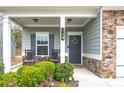 Inviting front porch features rocking chairs, stone accents, and a charming entrance at 133 Prominence Ct, Canton, GA 30114