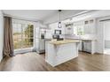 Spacious kitchen featuring a stainless steel refrigerator, granite countertops, white cabinets, and a large window at 2840 Ivy Mill Dr, Buford, GA 30519