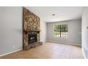 The living room boasts a stone fireplace and neutral walls for a cozy atmosphere, illuminated by a window at 910 Brandon Hill Way, Jonesboro, GA 30238
