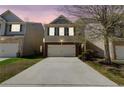 Charming two-story home featuring a two-car garage and manicured front lawn at sunset at 2205 Capella Sw Cir, Atlanta, GA 30331