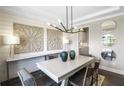 Dining room featuring wood-look accent wall, statement lighting, and elegant decor, creating a cozy yet stylish atmosphere at 4256 Azalea Ridge Way, Hoschton, GA 30548