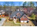 Aerial view of brick home, showcasing its position on a lot with mature trees and proximity to neighboring houses at 525 James Lee Dr, Suwanee, GA 30024