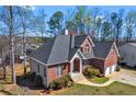 Angle view of the home showing brick and vinyl siding, roof, manicured lawn, and mature landscaping at 525 James Lee Dr, Suwanee, GA 30024