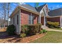 Close view of the vinyl siding and brick on this home, accented by landscaped gardens and trimmed hedges at 525 James Lee Dr, Suwanee, GA 30024