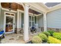 Close-up of a charming front porch with stone accents, rocking chairs, and a decorative front door at 161 Dorys Way, Dallas, GA 30157