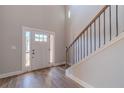Inviting entryway with wood-look floors, staircase with metal balusters, and natural light from the front door at 210 Pinewood Dr, Covington, GA 30014