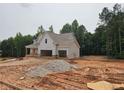 New construction home with a front porch and 2-car garage nestled amongst lush trees at 210 Pinewood Dr, Covington, GA 30014