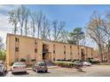 Apartment building exterior showcasing well-maintained landscaping and ample parking at 2390 Lawrenceville Hwy # K, Decatur, GA 30033