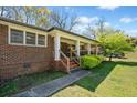 A brick home featuring an inviting covered front porch with a brick staircase and manicured lawn at 1286 Calhoun Sw Ter, Atlanta, GA 30314