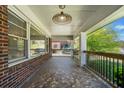Covered front porch offering a view of the neighborhood, mosaic tile floor, and decorative light fixture at 1286 Calhoun Sw Ter, Atlanta, GA 30314