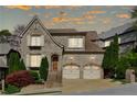 Charming brick home with a two-car garage, manicured landscaping, and inviting curb appeal at sunset at 1820 Buckhead Valley Ne Ln, Atlanta, GA 30324