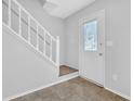 Welcoming entryway with staircase and glass-paneled front door, featuring light neutral walls at 2143 Victoria Pl, Lithonia, GA 30058