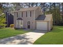 Inviting two-story home with lush lawn, bay windows, and attached garage on a sunny day at 2143 Victoria Pl, Lithonia, GA 30058