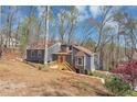 Charming gray home nestled in a wooded area, featuring a walkway and lots of natural light, with ample privacy at 980 Pine Grove Pointe Dr, Roswell, GA 30075