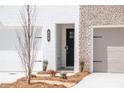 New townhome with white and light brick exterior, black door, and attached garages at 105 Priestwood Ln, Acworth, GA 30102