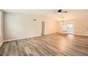 Bright living room featuring gray wood floors, high ceilings, and a modern ceiling fan at 4953 Apple Valley Rd, Douglasville, GA 30135